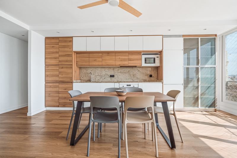 Cocina office con frentes de madera y mesa de comedor