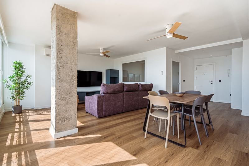 Salón amplio con suelo de madera y luz de tarde