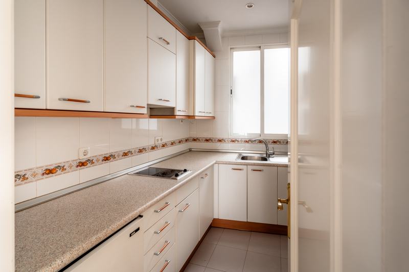 Cocina en línea con encimera de granito y office al fondo