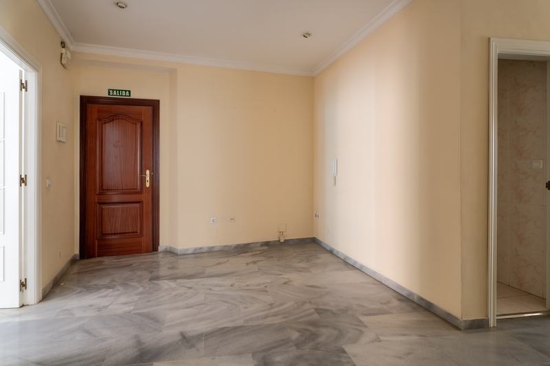 Recibidor con puerta de madera y suelo de mármol