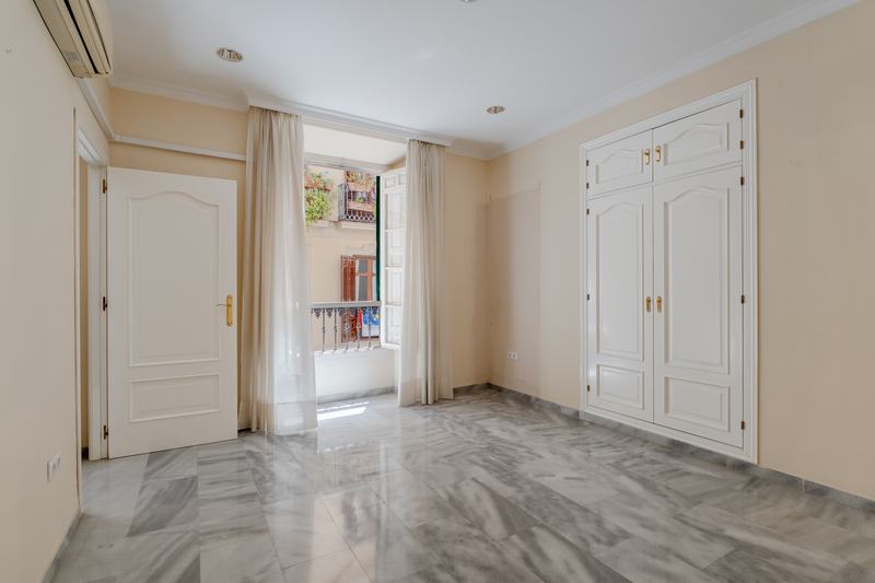 Sala con armario empotrado de cuarterones y balcón