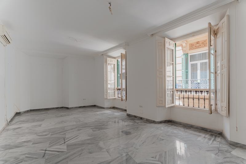 Sala diáfana con dos balcones abiertos a la calle