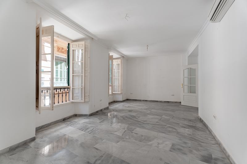 Sala vacía con suelo de mármol y ventanas a la fachada