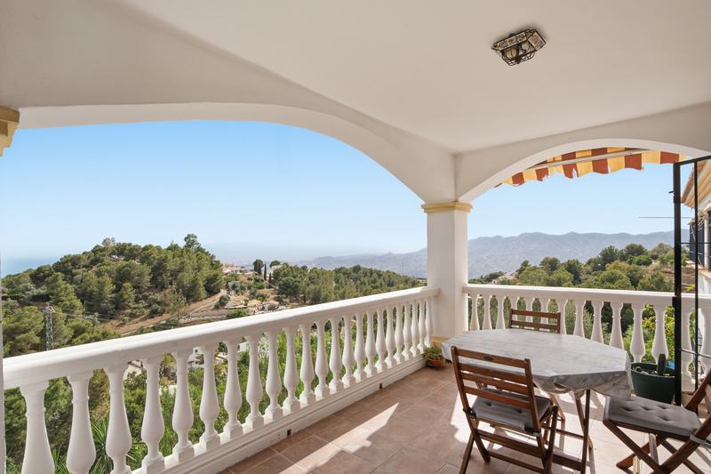 Terraza de una villa con balaustrada y vistas a la sierra