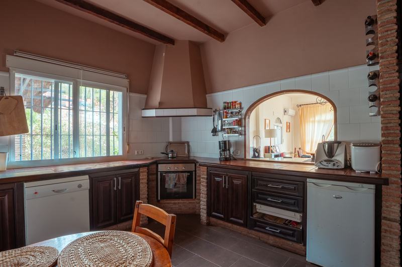 Cocina rústica con vigas vistas y campana de obra
