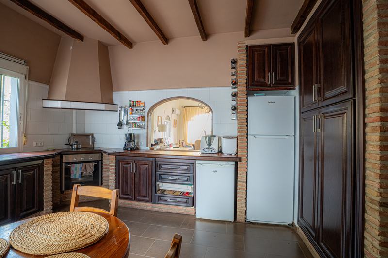 Cocina con arco de ladrillo y office de madera