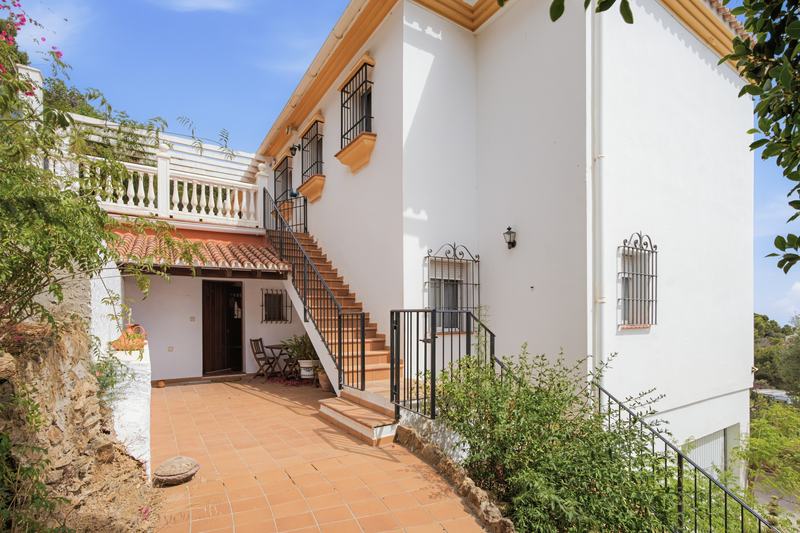 Fachada con balcón corrido y escalera de acceso