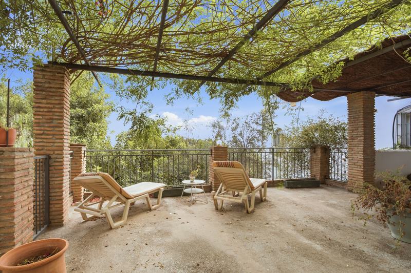 Pérgola con tumbonas y vistas abiertas al valle