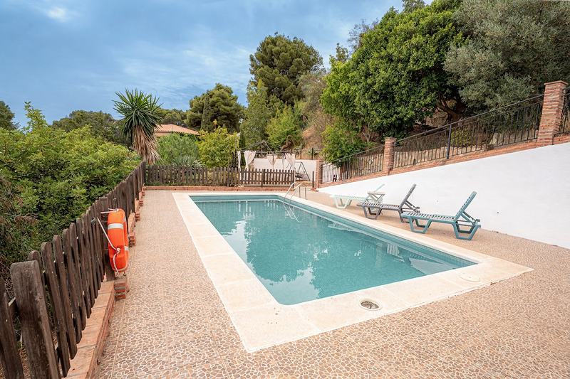 Piscina exterior con tumbonas y vegetación mediterránea