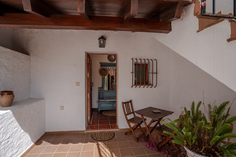 Porche de entrada con vigas de madera y mesa plegable